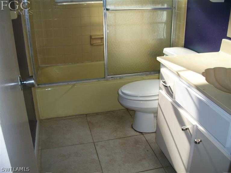 1802 Ridgecrest Street Lehigh Acres, FL 33936 - Photo 8 of 10 a bathroom with a toilet and a shower