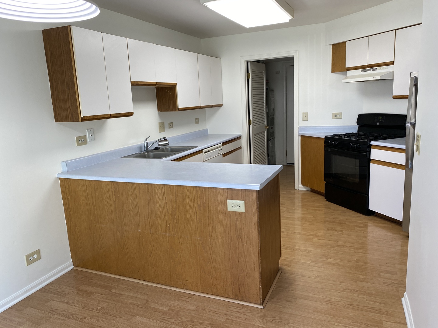 720 Daybreak Lane, Unit 720 Carol Stream, IL 60188 - Photo 9 of 22 a kitchen with wooden cabinets a sink a stove and a refrigerator
