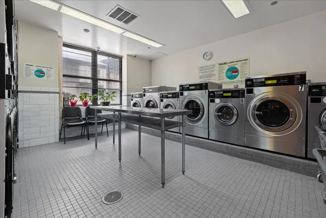 a utility room with dryer washer and a view of living room