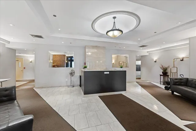 a large living room with a large mirror and a view of living room