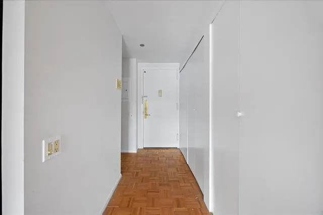 a view of a hallway with wooden floor and staircase