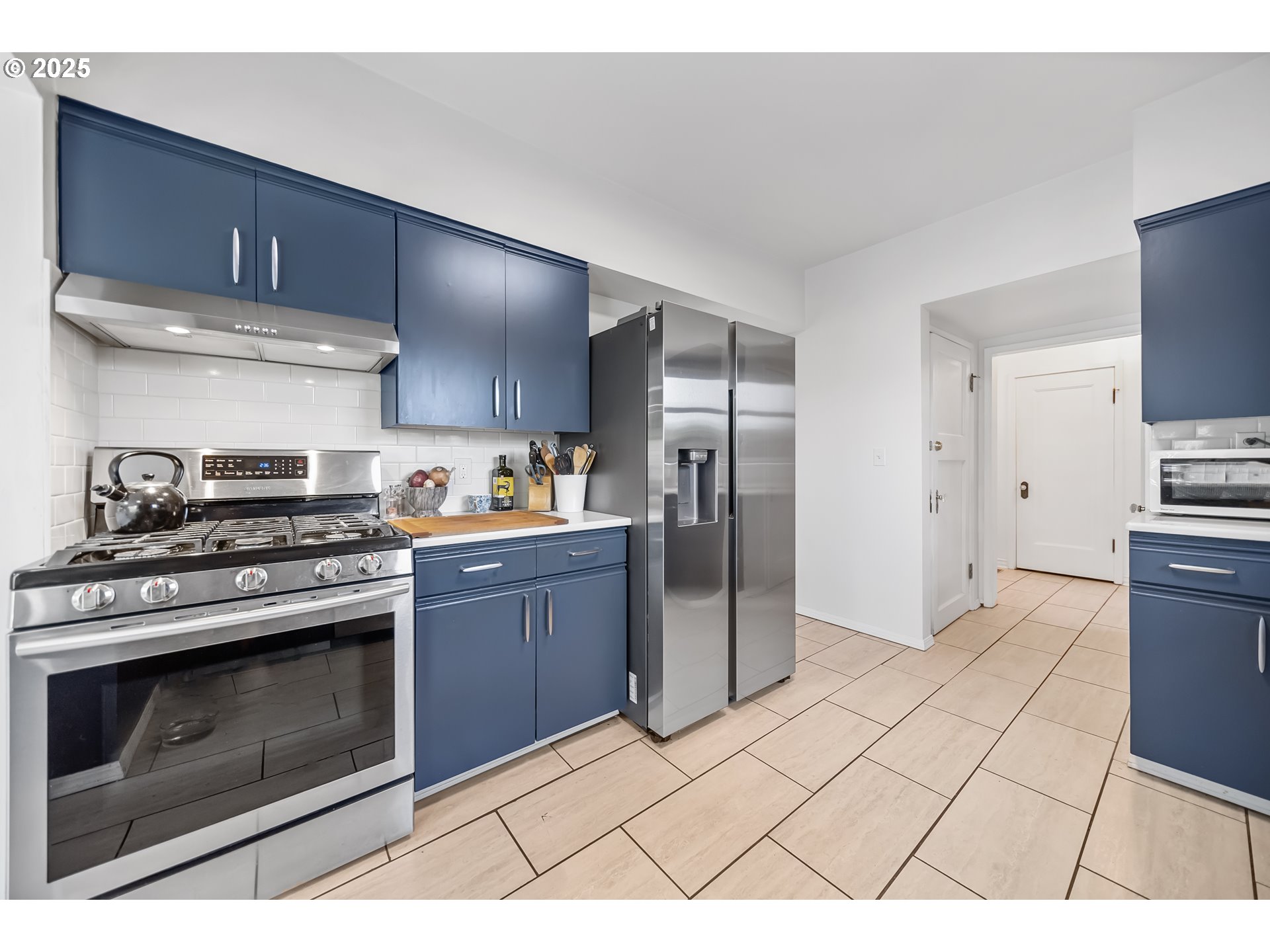 6026 Northeast 57th Avenue Portland, OR 97218 - Photo 11 of 45 a kitchen with stainless steel appliances a stove a refrigerator and cabinets