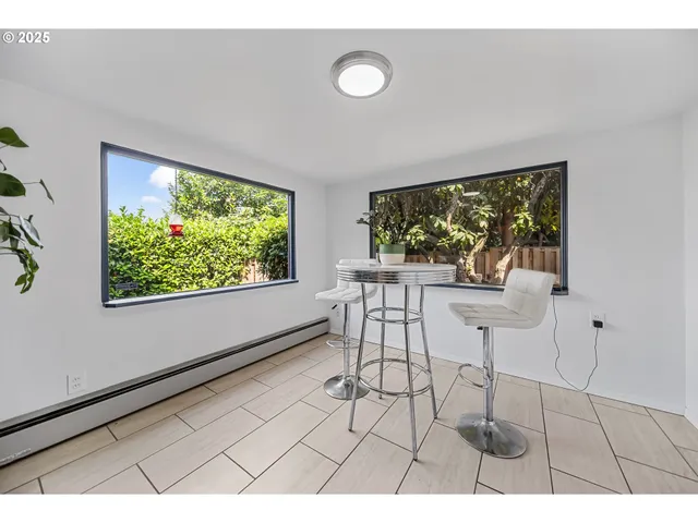 a dining room with furniture and a large window