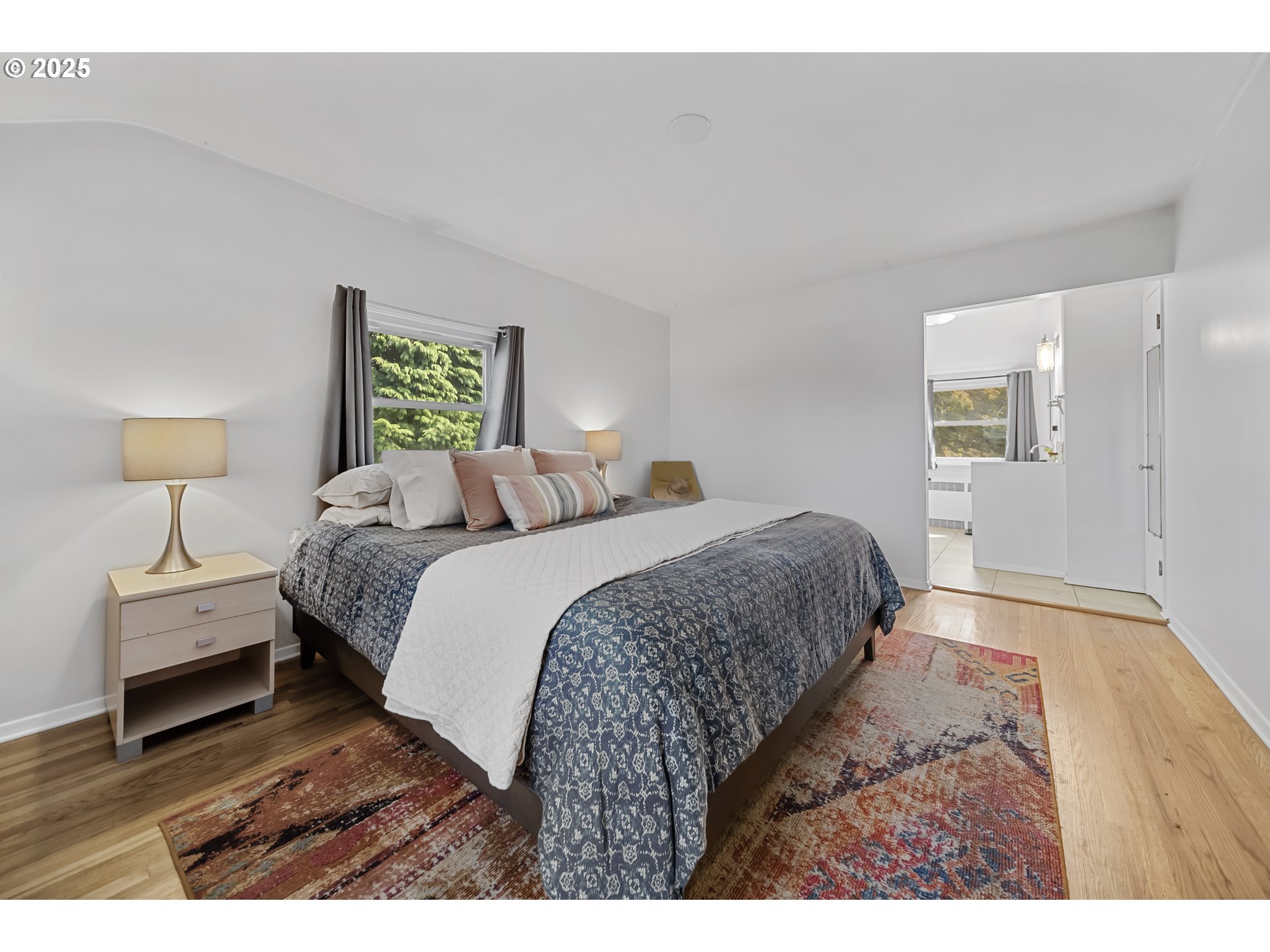 6026 Northeast 57th Avenue Portland, OR 97218 - Photo 14 of 45 a bedroom with a bed and wooden floor