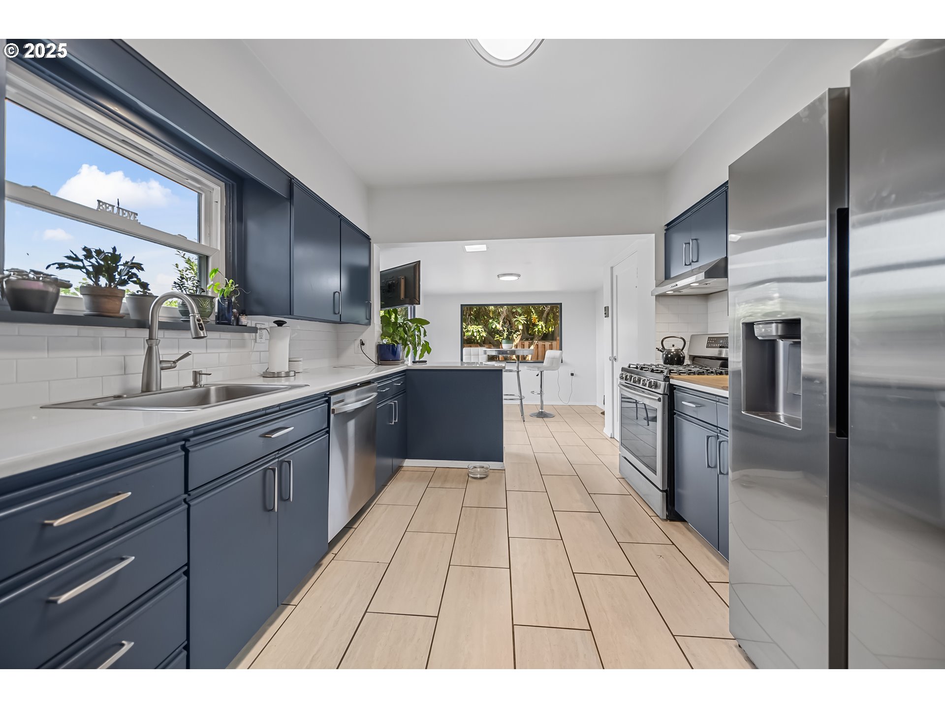 6026 Northeast 57th Avenue Portland, OR 97218 - Photo 10 of 45 a large kitchen with a large counter top stainless steel appliances and cabinets