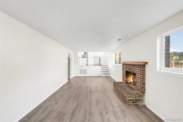a view of empty room with wooden floor and fireplace