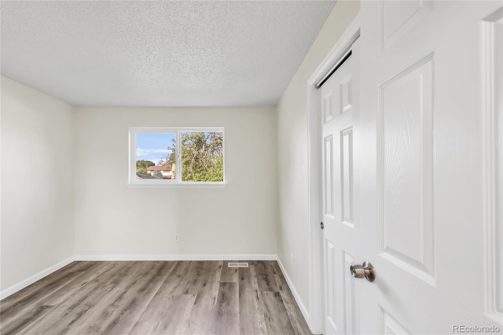 9215 Lowell Boulevard Westminster, CO 80031 - Photo 16 of 30 an empty room with wooden floor and windows