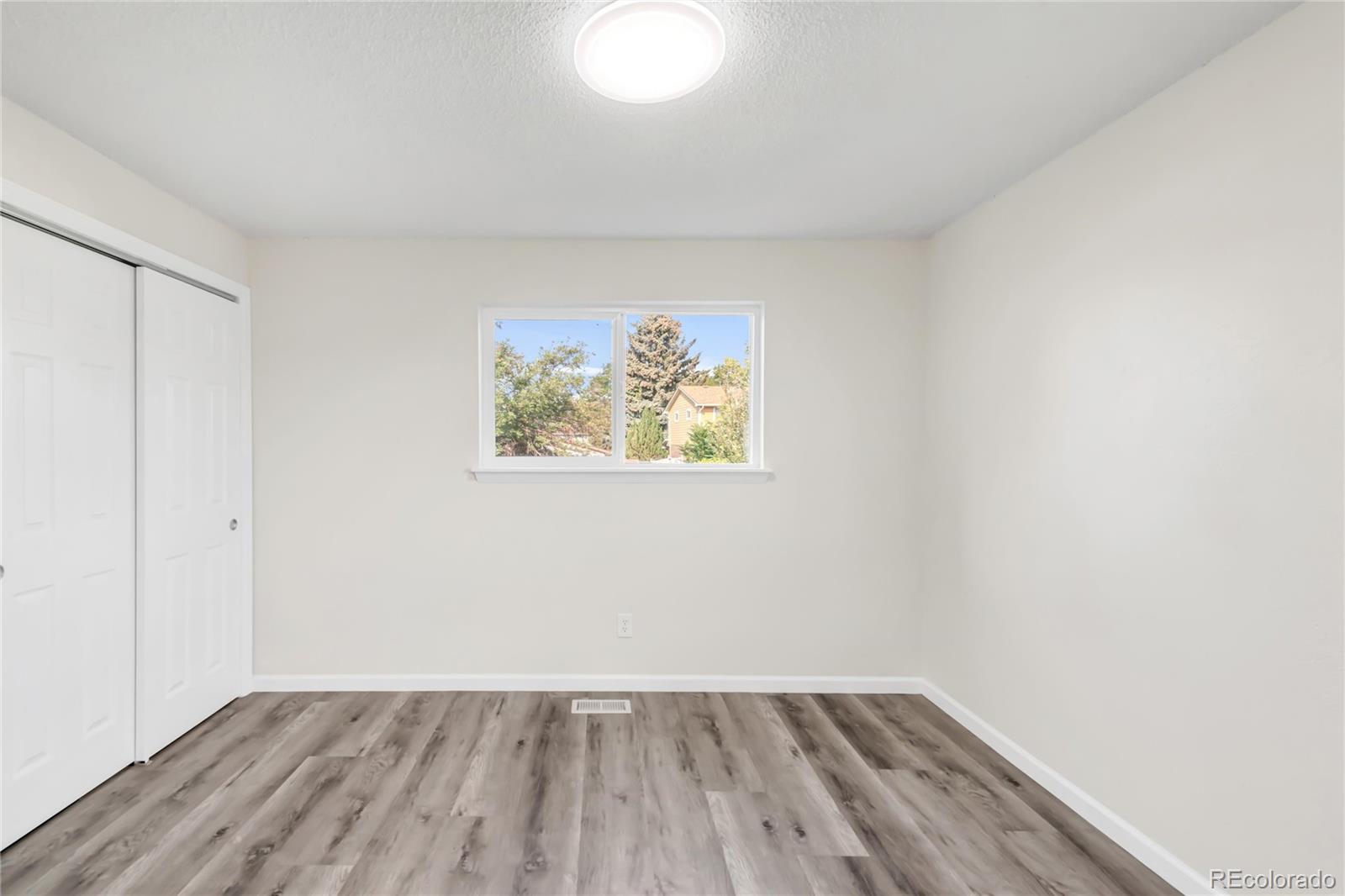 9215 Lowell Boulevard Westminster, CO 80031 - Photo 22 of 30 an empty room with wooden floor and windows