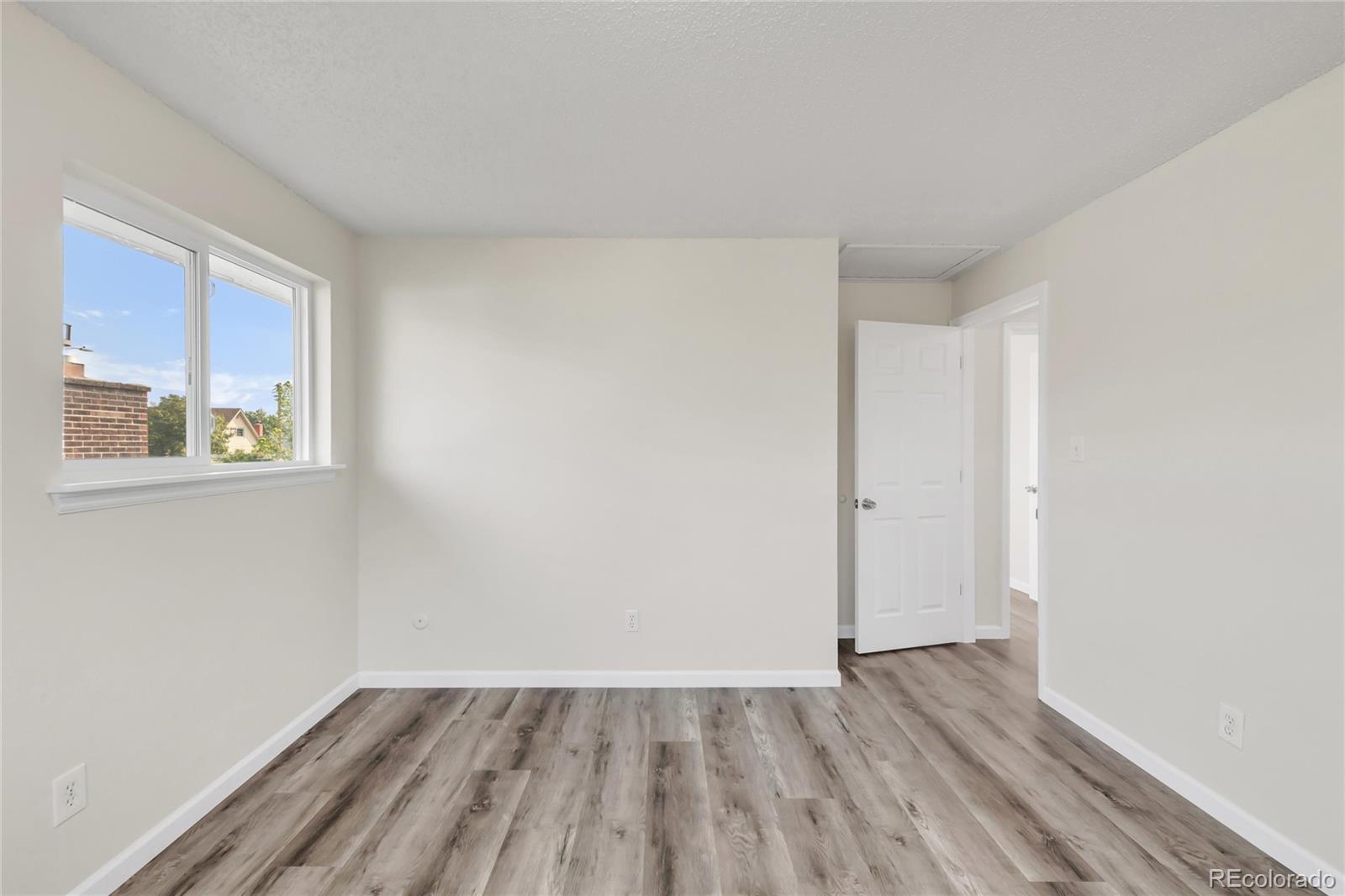 9215 Lowell Boulevard Westminster, CO 80031 - Photo 23 of 30 a view of an empty room with wooden floor and a window