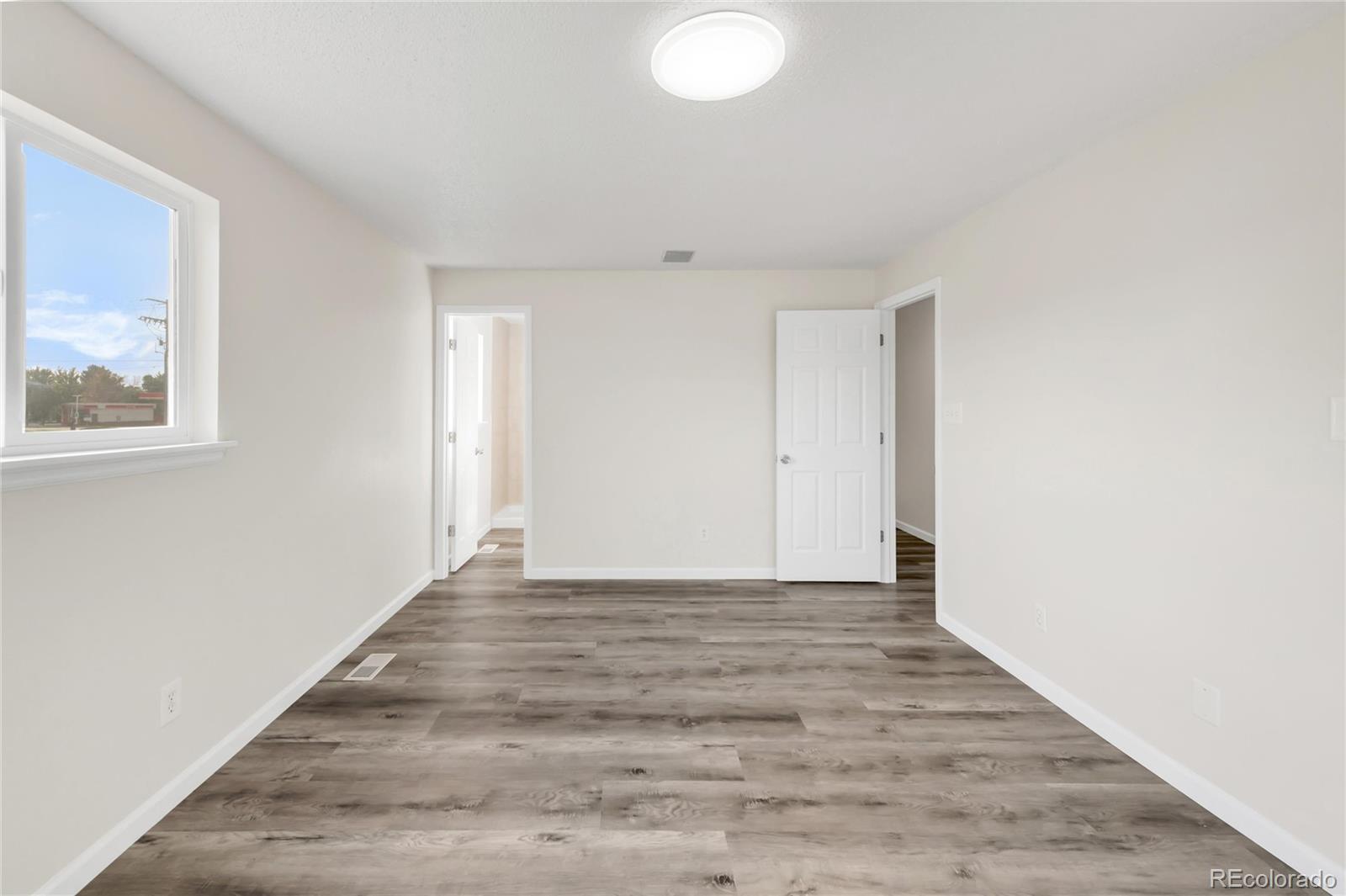 9215 Lowell Boulevard Westminster, CO 80031 - Photo 25 of 30 a view of an empty room with wooden floor and a window