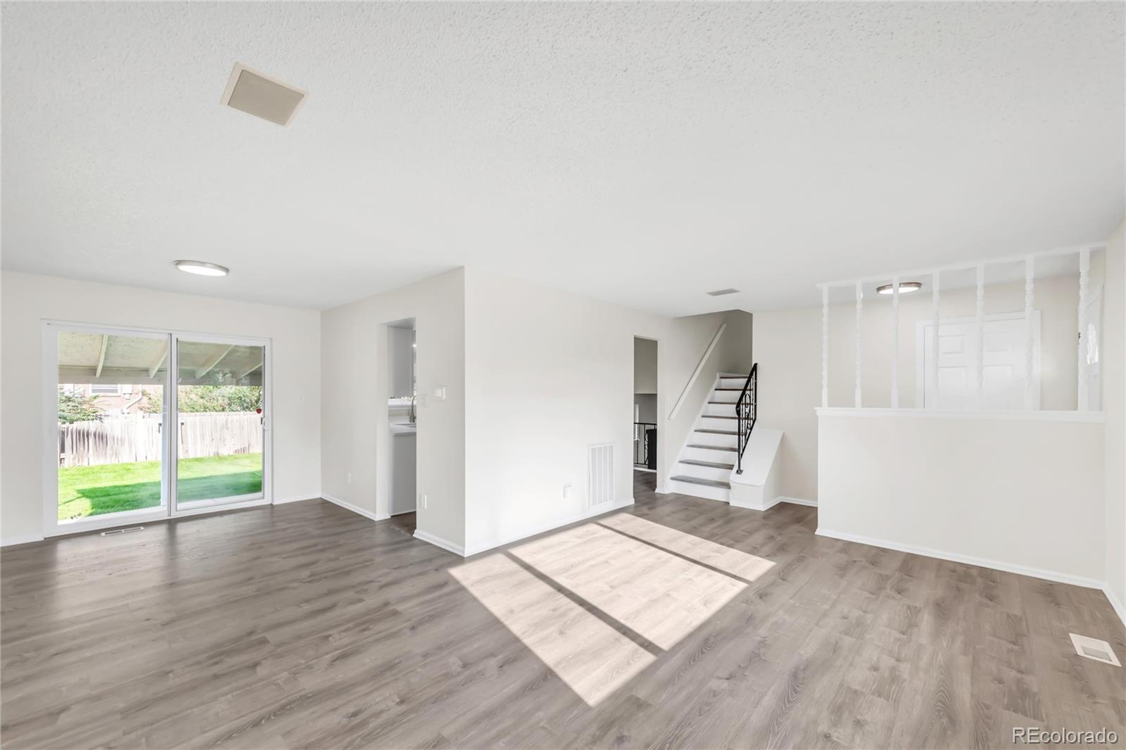 9215 Lowell Boulevard Westminster, CO 80031 - Photo 5 of 30 an empty room with wooden floor and windows