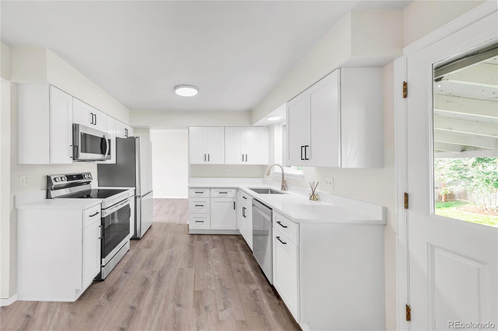 9215 Lowell Boulevard Westminster, CO 80031 - Photo 7 of 30 a kitchen with stainless steel appliances sink stove top oven and refrigerator