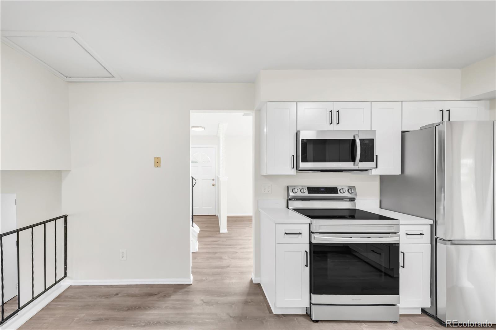 9215 Lowell Boulevard Westminster, CO 80031 - Photo 9 of 30 a kitchen with stainless steel appliances a refrigerator stove and white cabinets