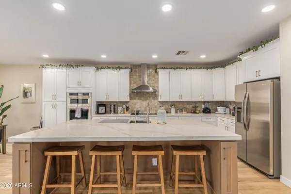 a kitchen with stainless steel appliances granite countertop a sink a stove and a refrigerator