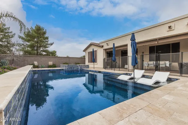 a view of a house with pool and chairs