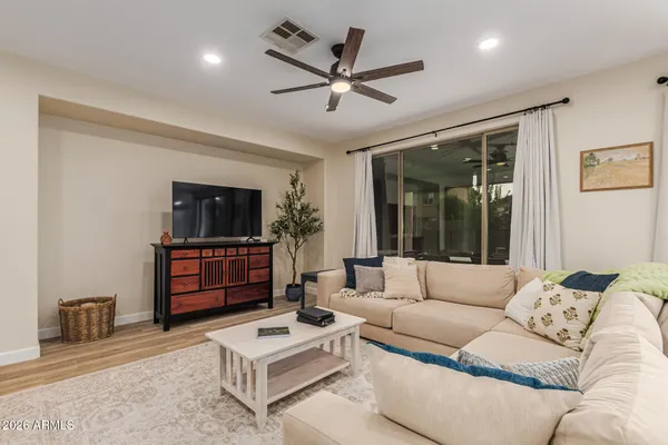 a living room with furniture a ceiling fan and a window