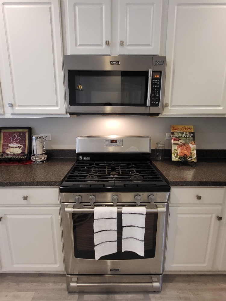 2949 Brossman Street Naperville, IL 60564 - Photo 14 of 61 a stove top oven sitting inside of a kitchen and white cabinets
