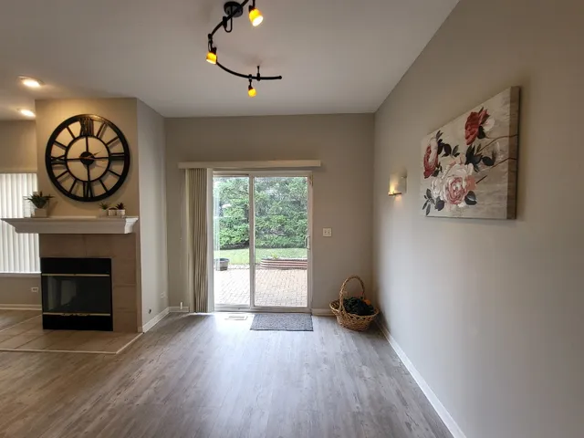 an empty room with wooden floor a fireplace and window
