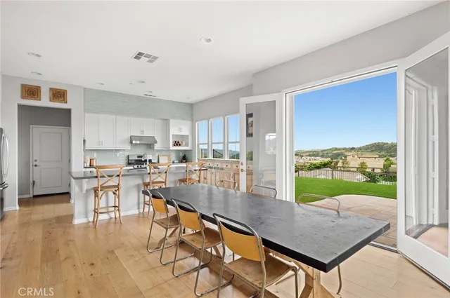 a kitchen with a table chairs and wooden floor