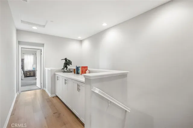 a view of a hallway with white cabinets
