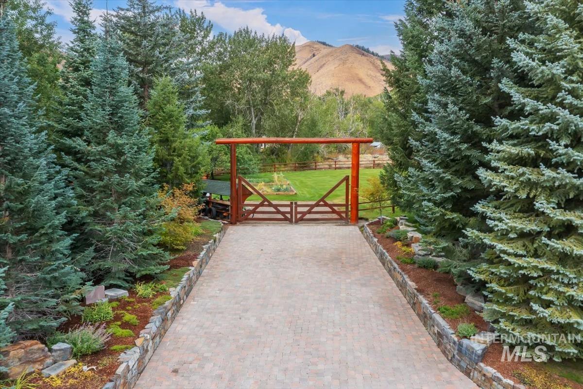 106 Hidden Hollow Road Hailey, ID 83333 - Photo 16 of 49 Paver driveway framed by mature evergreen trees and stone retaining walls