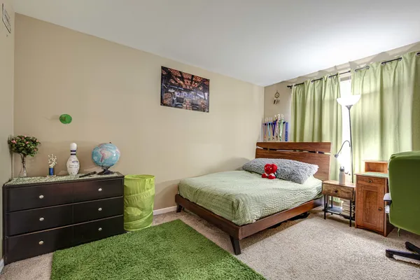 a bedroom with a bed and a potted plant