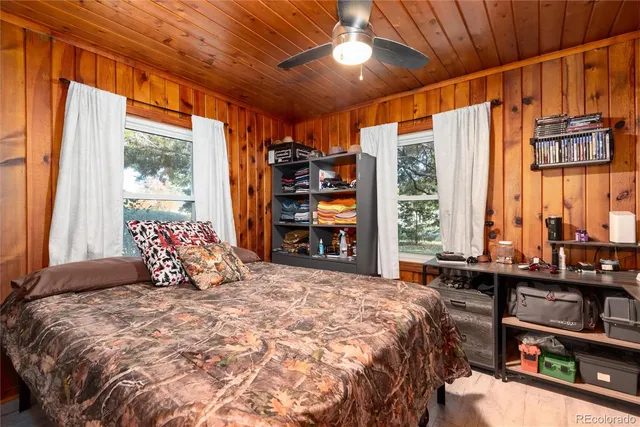 a bedroom with a bed and a dresser next to a window