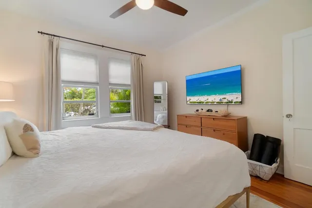 a bedroom with a bed tv and a window