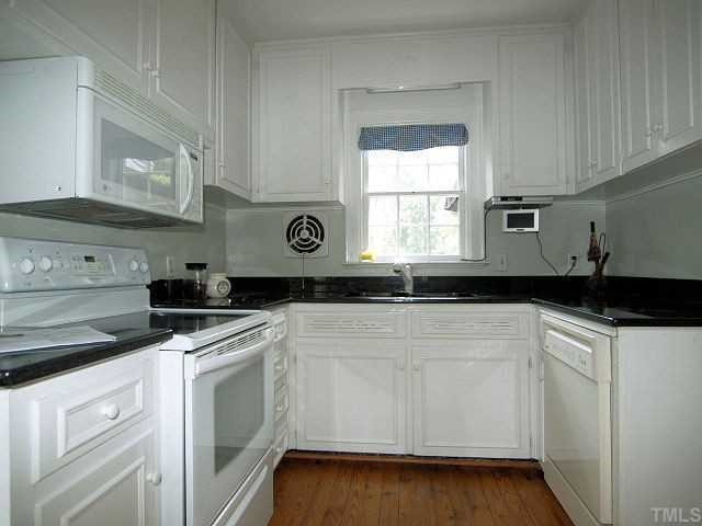 UPDATED EAT-IN KITCHEN WITH GRANITE COUNTERTOPS, HEART OF PINE FLOORS, LIGHT CABINETS, AND FRESH PAINT. Kitchen