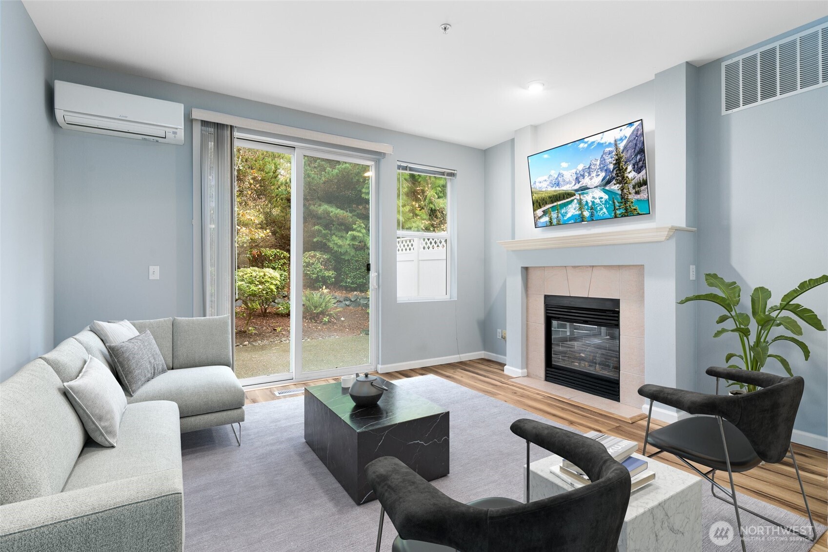 a living room with furniture a large window and a fireplace