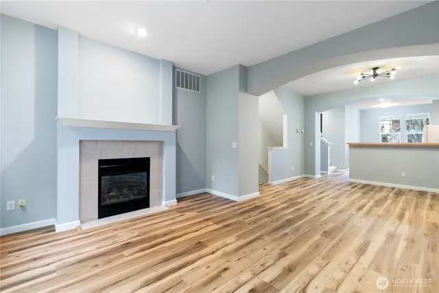 a view of an empty room with a fireplace and a window