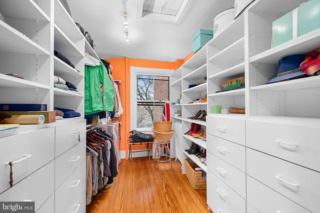a view of walk in closet with clothes and shoes