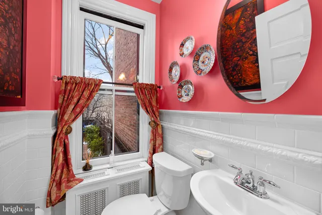 a bathroom with a toilet a sink and a mirror