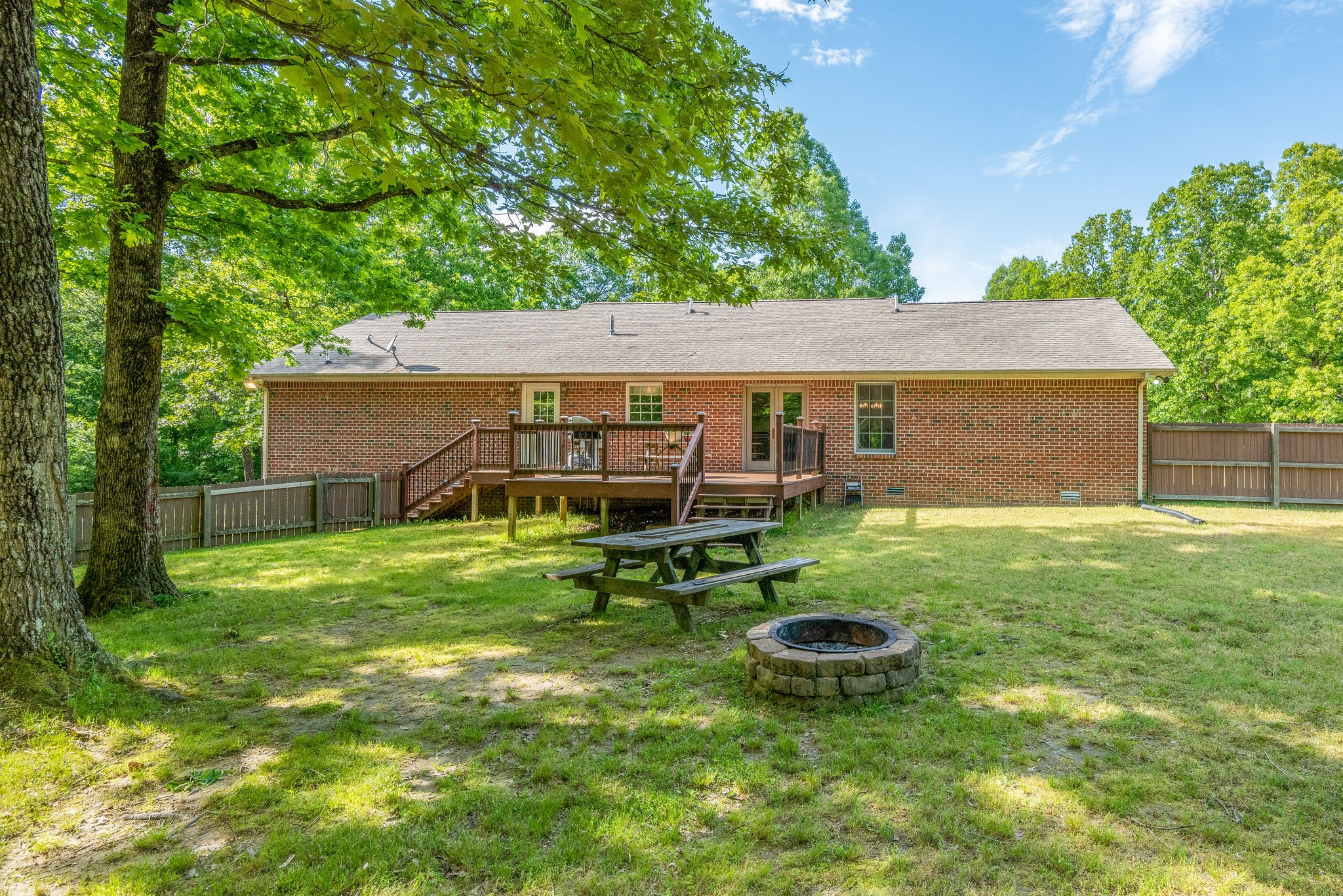 770 Iron Hill Road Burns, TN 37029 - Photo 26 of 28 a view of a backyard with table and chairs and potted plants and large tree