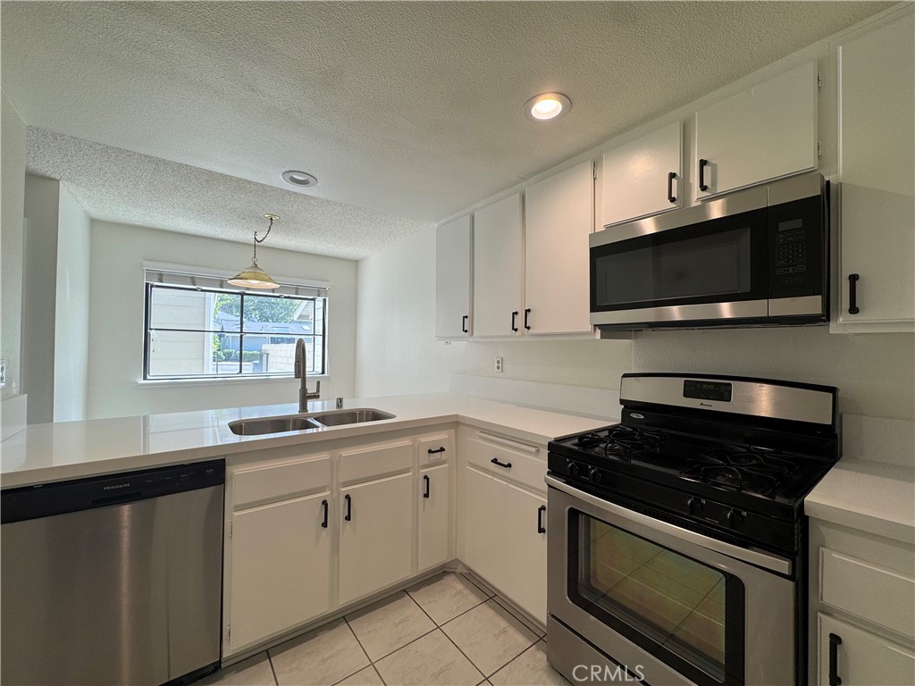 1819 Molokai Street West Covina, CA 91792 - Photo 4 of 25 a kitchen with a sink stove and microwave