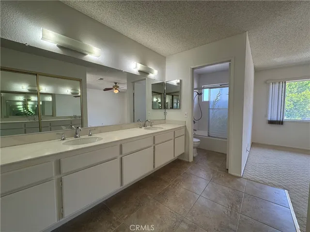 a large bathroom with a double vanity sink a large mirror and a shower