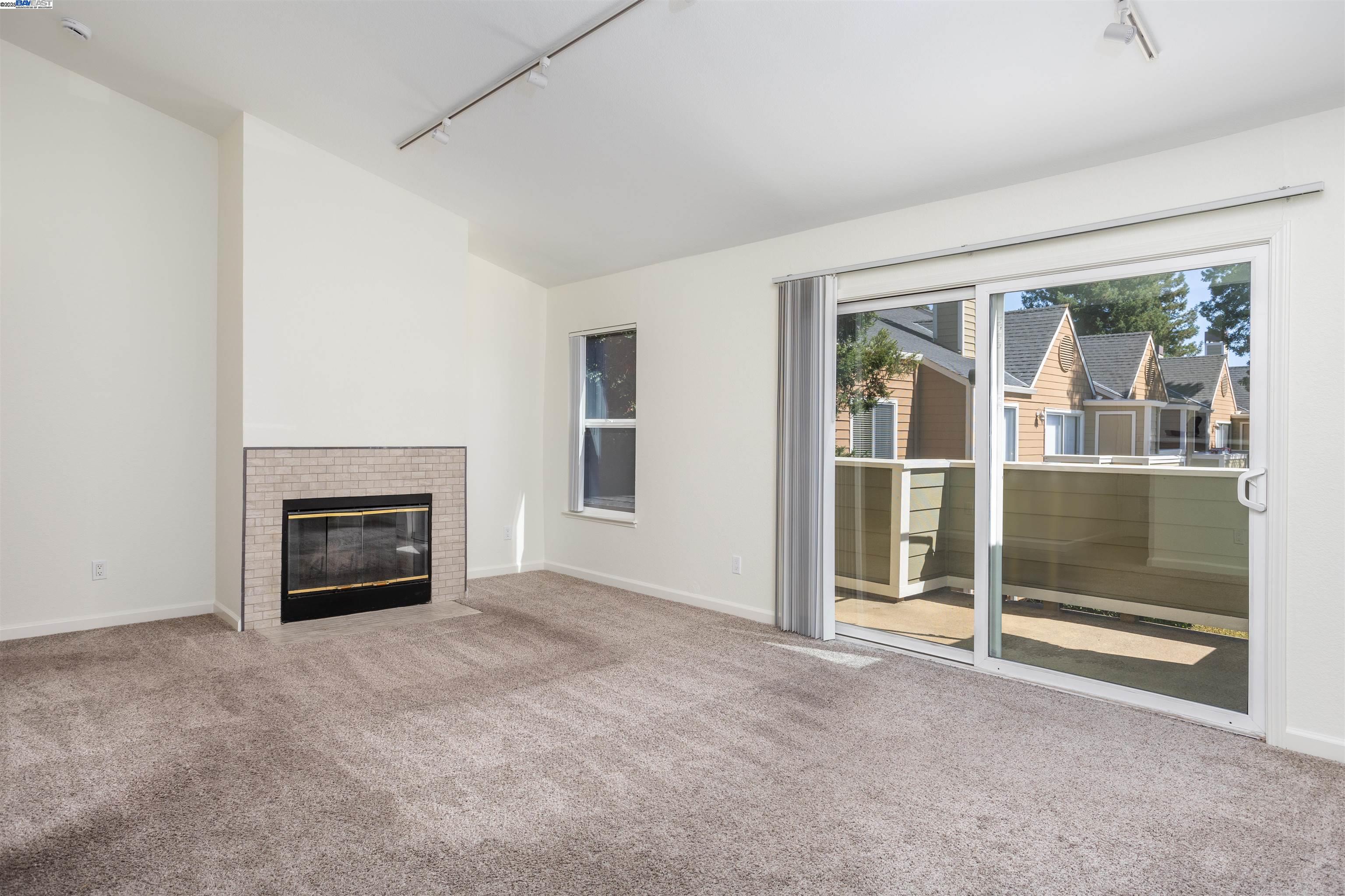 140 Reflections Drive, Unit 24 San Ramon, CA 94583 - Photo 2 of 32 an empty room with floor to ceiling window and fireplace