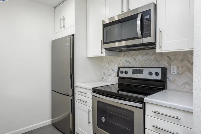 a kitchen with stainless steel appliances a stove microwave and refrigerator