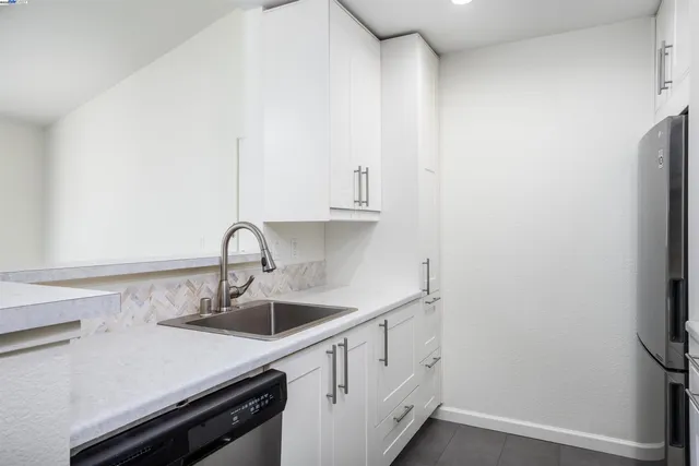 a kitchen with a sink and white cabinets