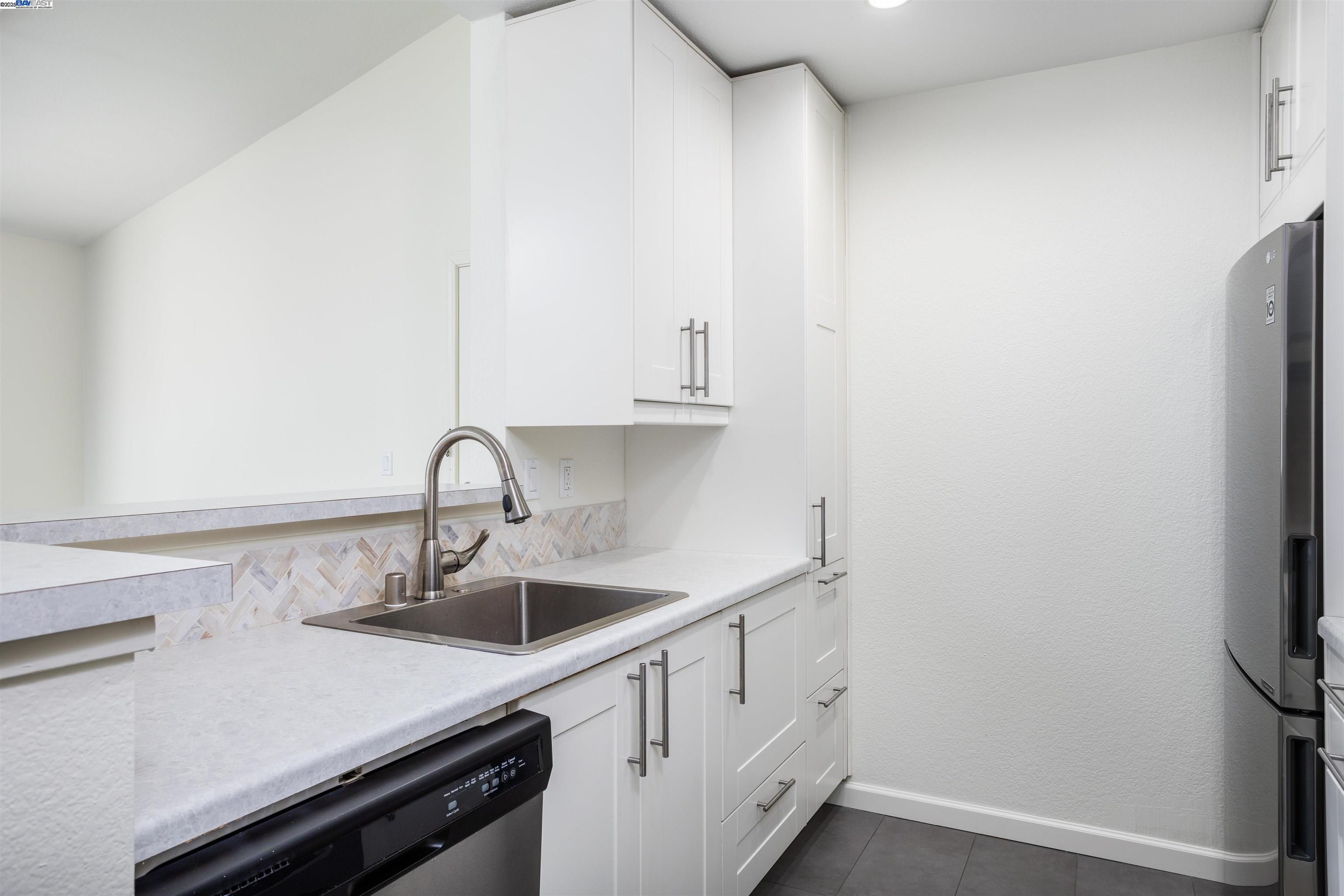 140 Reflections Drive, Unit 24 San Ramon, CA 94583 - Photo 9 of 32 a kitchen with a sink and white cabinets