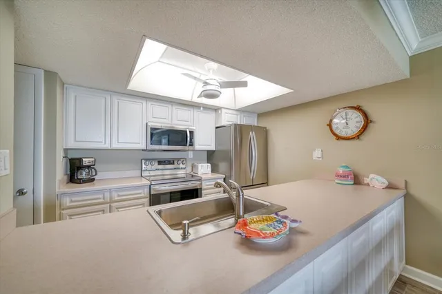 a kitchen that has a microwave a stove and a sink