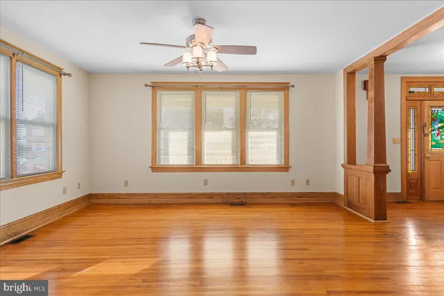 a view of an empty room with a window and wooden floor