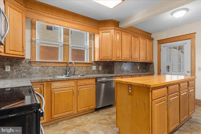 a kitchen with stainless steel appliances granite countertop a sink stove and cabinets