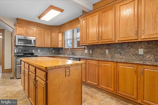 a kitchen with stainless steel appliances granite countertop wooden cabinets a sink and a dishwasher