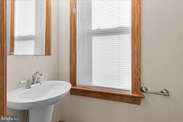 a bathroom with a sink a mirror and a window