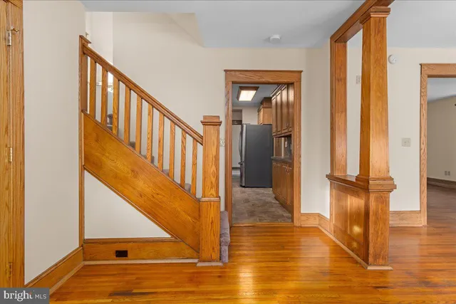 a view of a hallway with wooden floor and staircase