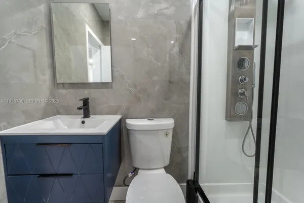 a bathroom with a toilet sink and mirror