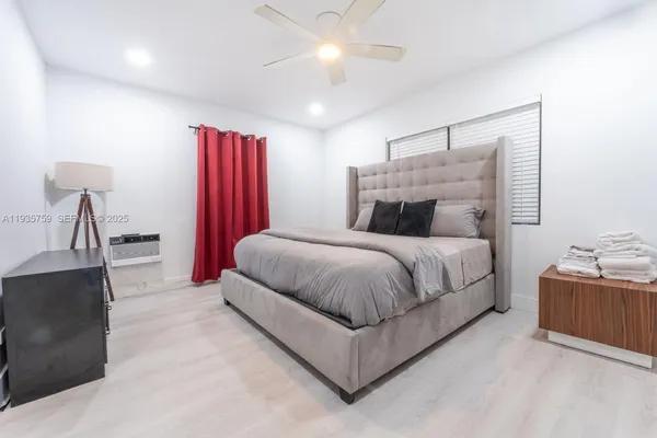 a spacious bedroom with a bed and a chandelier