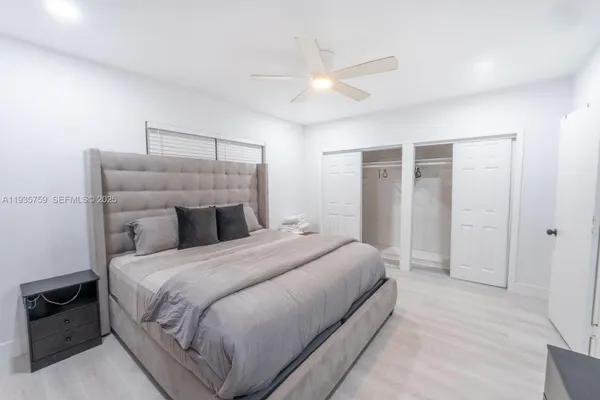 a bedroom with a bed and a ceiling fan