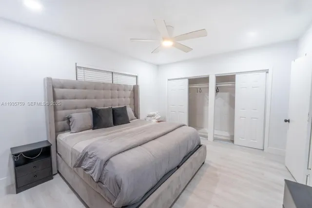 a bedroom with a bed and a ceiling fan